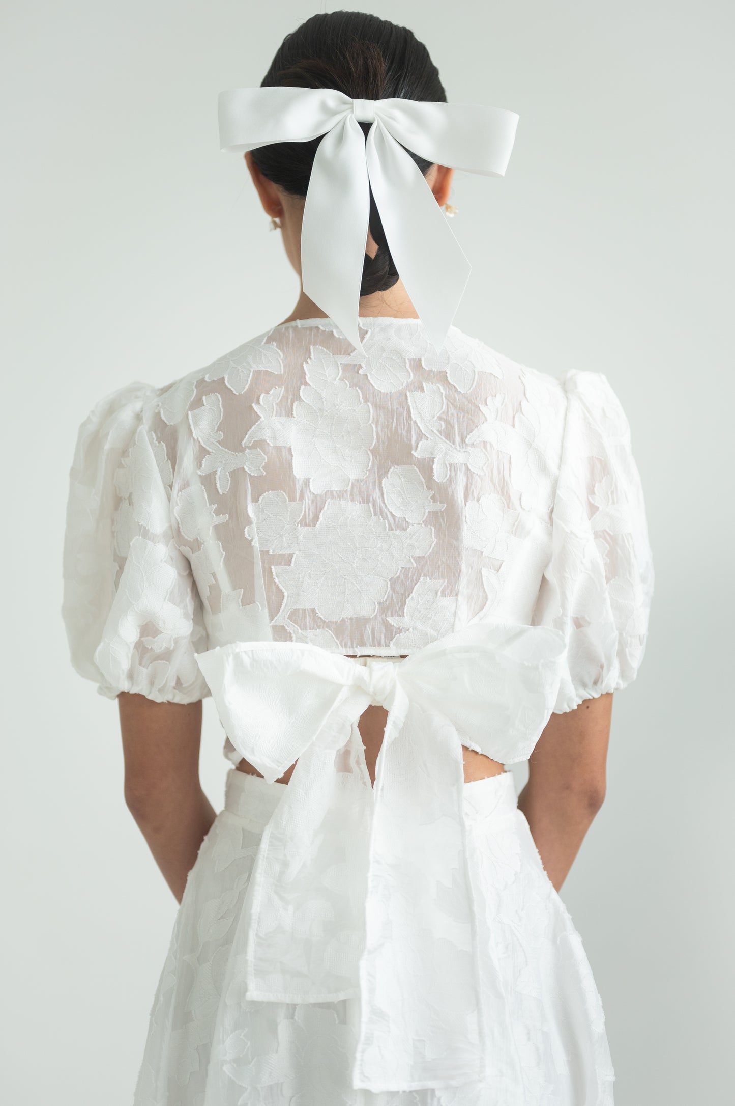 A sheer floral wrap top with short puffed sleeves and elastic cuffs.