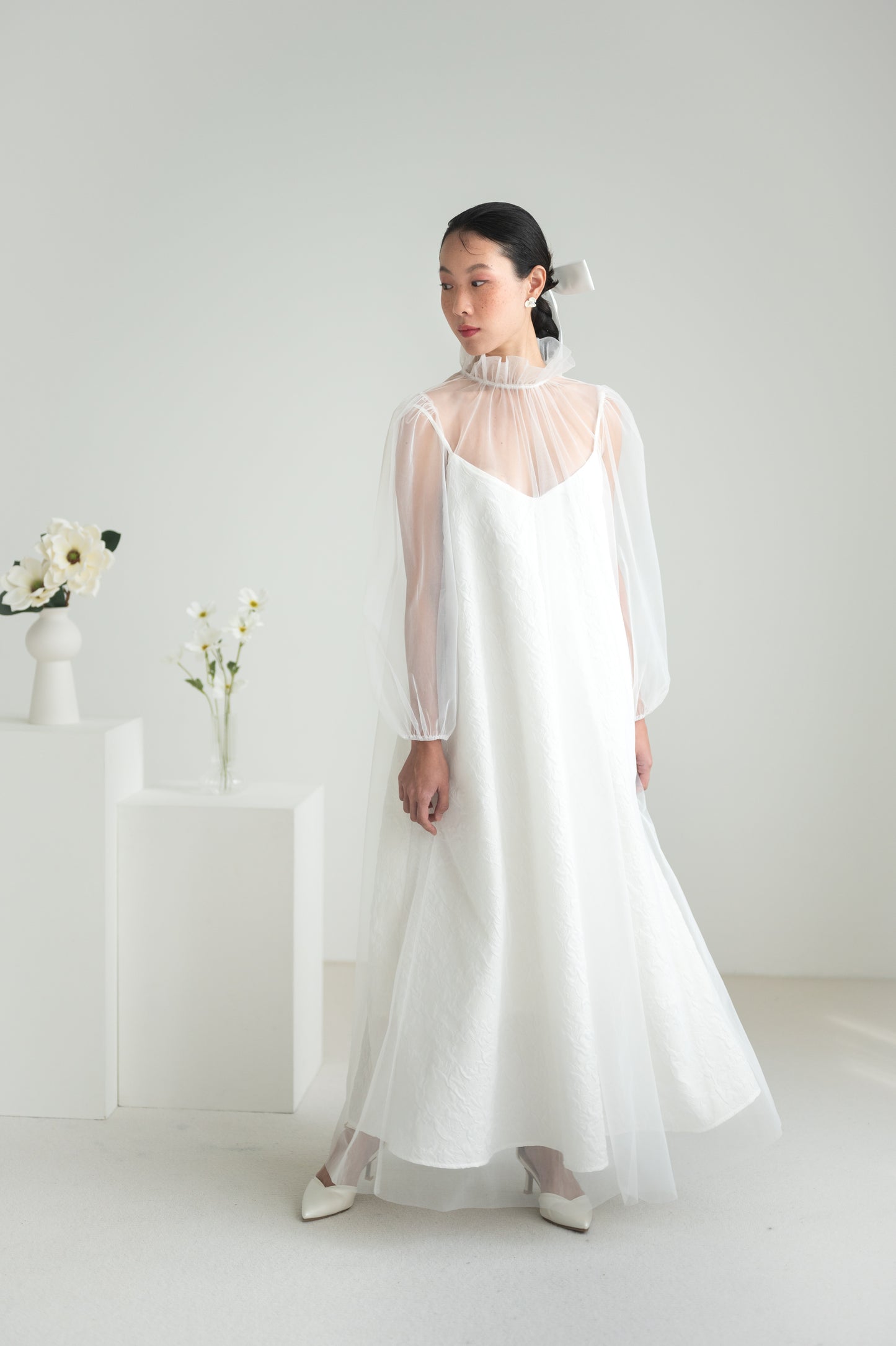 Sheer tulle dress with a high ruffled collar, puffed sleeves with elastic cuffs, and a keyhole button closure at the back.