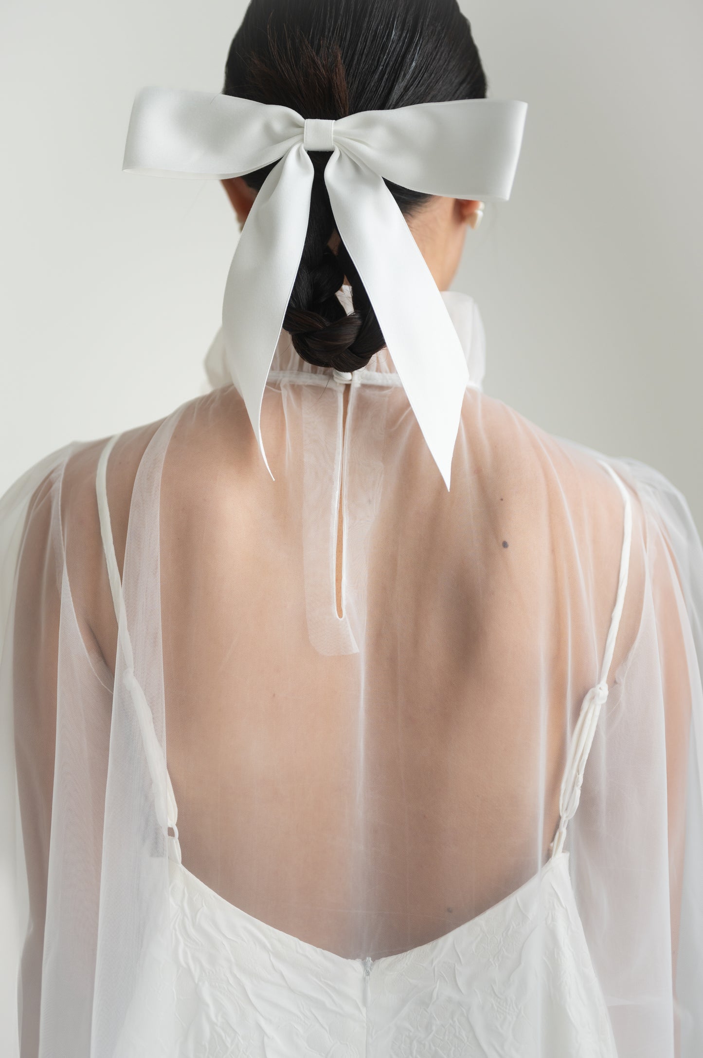 Sheer tulle dress with a high ruffled collar, puffed sleeves with elastic cuffs, and a keyhole button closure at the back.