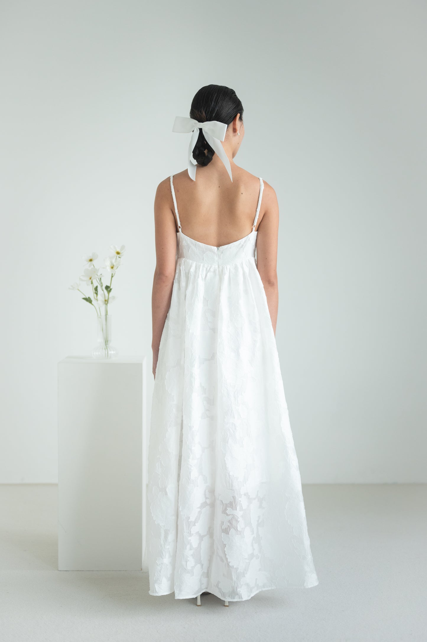 Empire waist dress with a voluminous skirt, adjustable straps, and functional pockets.