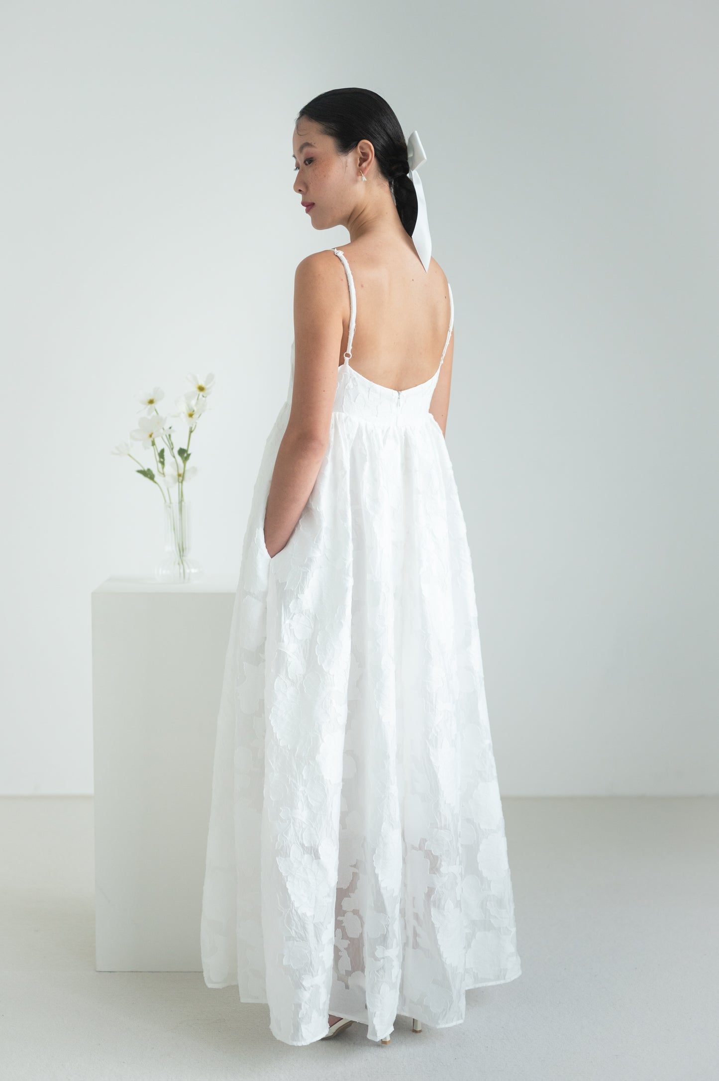 Empire waist dress with a voluminous skirt, adjustable straps, and functional pockets.