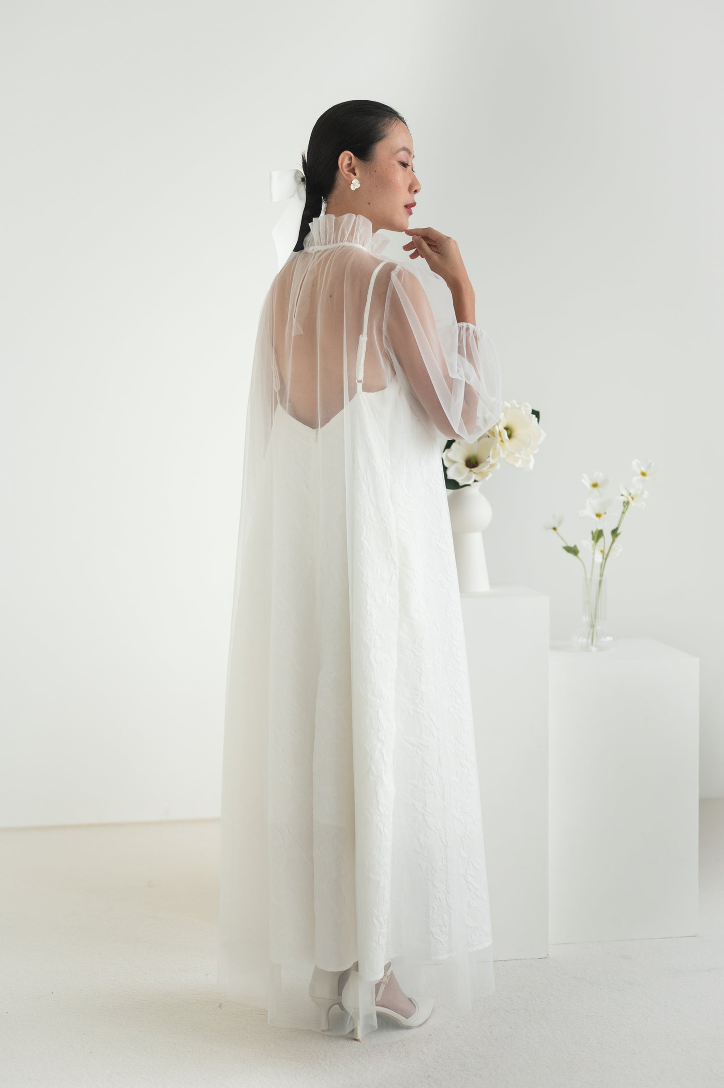 Sheer tulle dress with a high ruffled collar, puffed sleeves with elastic cuffs, and a keyhole button closure at the back.