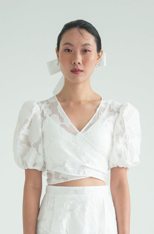 A sheer floral wrap top with short puffed sleeves and elastic cuffs.